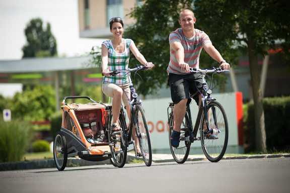 Familie mit Fahrrad bei den Thermen Chalets